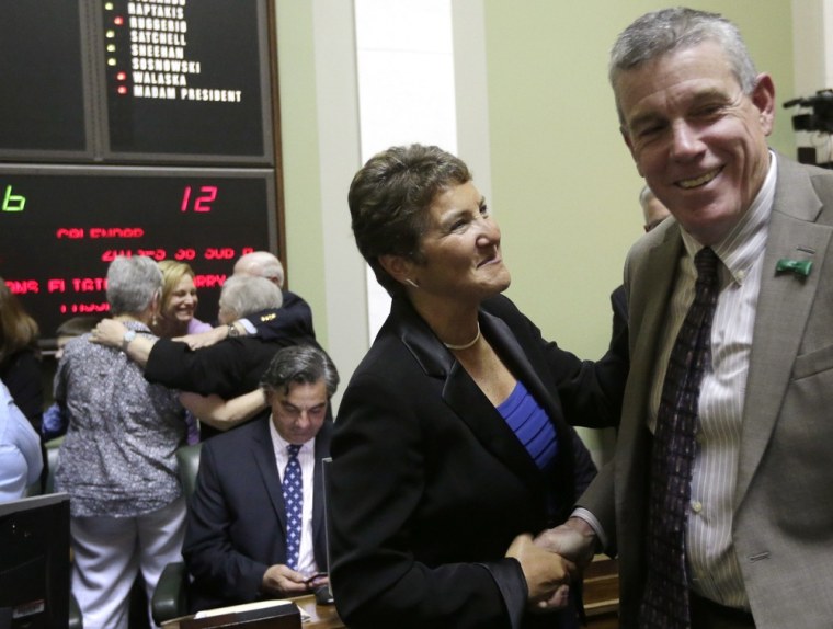 Rhode Island state Sen. Donna Nesselbush, D-Pawtucket (center) shakes hands with R.I. state Sen. Paul Fogarty, D-Glocester, moments after the state Senate passed a same-sex marriage bill Wednesday.