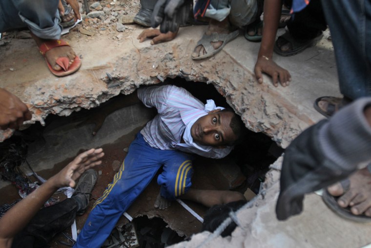 A rescuer looking for survivors emerges from beneath a concrete slab in Savar, Bangladesh, on April 25.