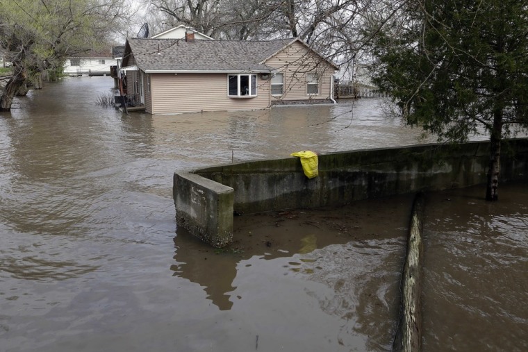 A home is surrounded by water Wednesday, April 24, 2013, in Peoria Heights, Ill.
