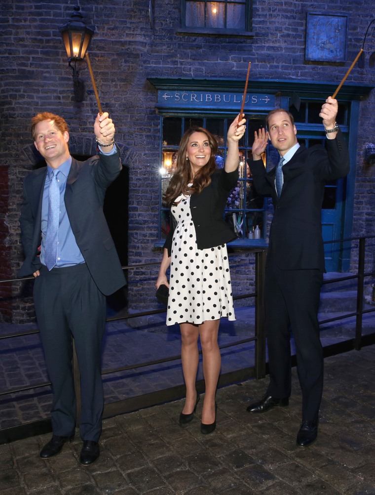 LONDON, ENGLAND - APRIL 26:  Prince Harry, Catherine, Duchess of Cambridge and Prince William, Duke of Cambridge raise their wands on the set used to ...