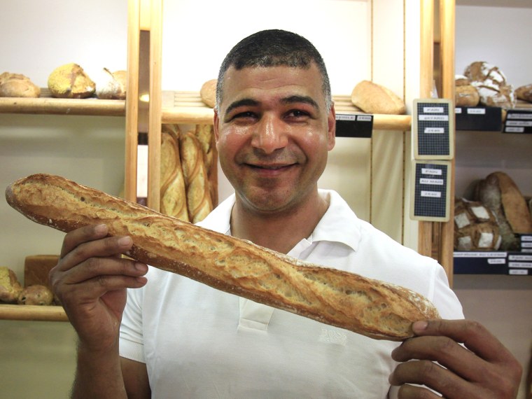 Ridha Khadher a Tunisian born baker stands in his Paris bakery, as he poses with one of his baguette, after winning the title of Best Baguette of Pari...