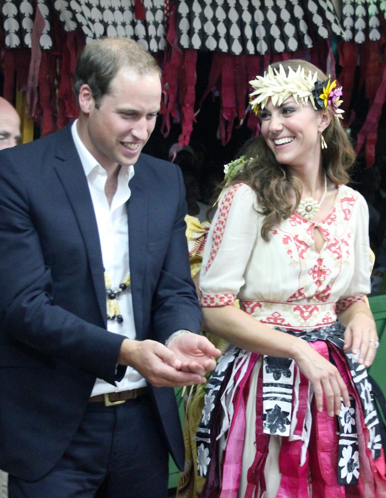 Britain's Prince William (L) and his wife Catherine (R), the Duchess of Cambridge, attend a 'fatale', a singing and dancing event, in Funafuti on Tuva...