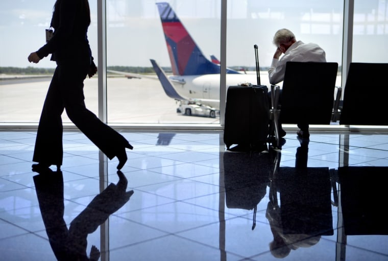 A passenger sits at right in the international terminal at Hartsfield-Jackson airport, Friday, April 26, 2013, in Atlanta.