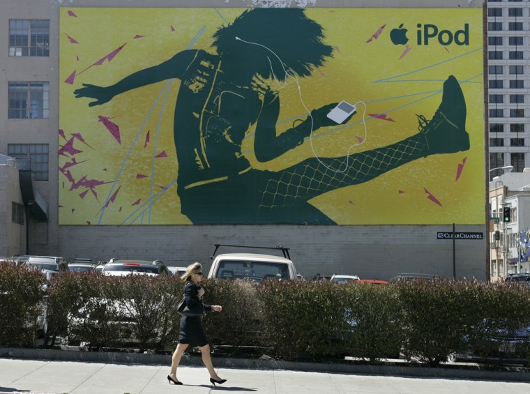 A woman listens to her portable music player while walking past an Apple Ipod billboard in San Francisco, Monday, April 23, 2007. Apple Inc., on a tea...