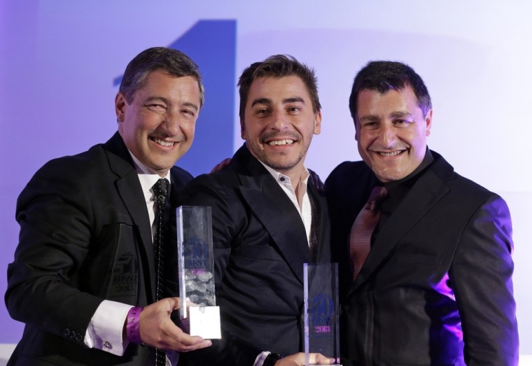 Head chef Joan Roca, left, accompanied by his brothers Jordi Roca, center, and Josep Roca, right,  pose for the photographers with their trophies afte...
