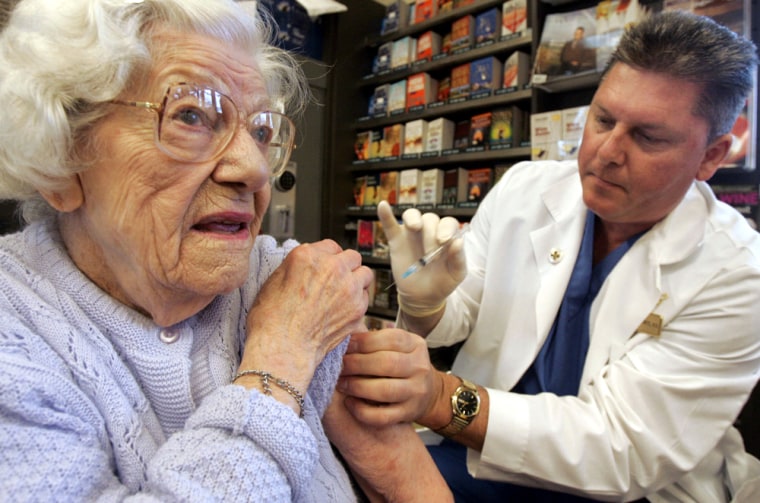 A registered nurse prepares to administer a flu shot.