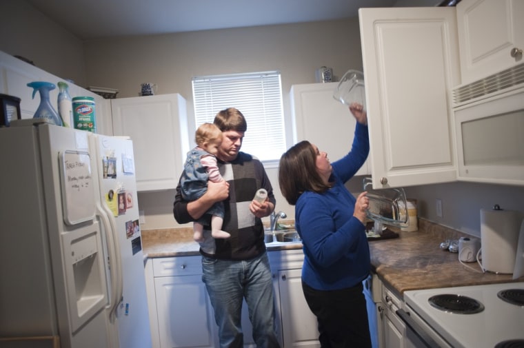 Samuel and Megan Moss stand in their kitchen with their 10-month-old daughter, Mary Margaret, at their apartment in Plano, Texas.