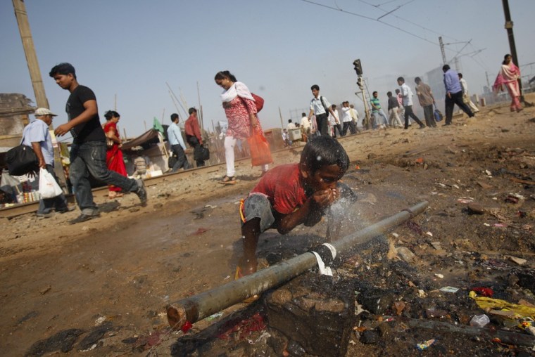 A boy drinks water out of a broken pipeline in a slum in Mumbai last month.