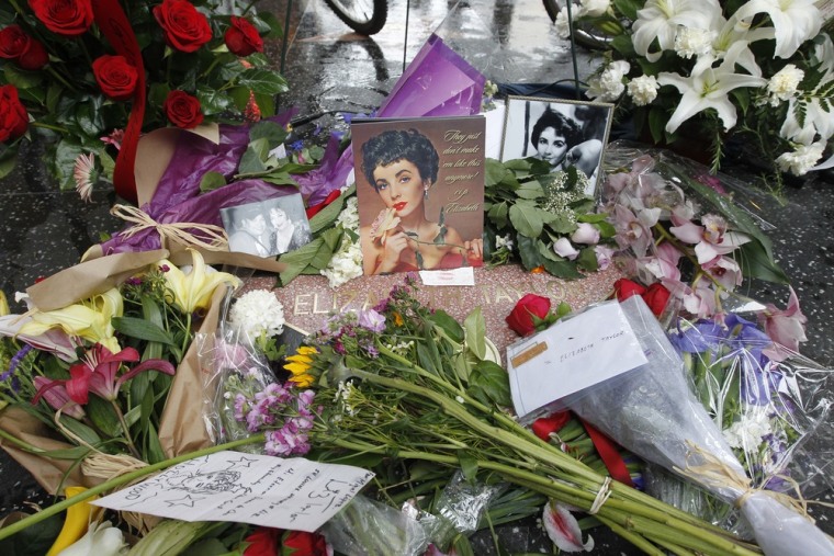 Flowers, photographs and notes from fans adorn the Hollywood Walk of Fame star of actress Elizabeth Taylor in Hollywood, California, March 23, 2011. Taylor died on March 23, 2011 at age 79 at Cedars-Sinai Hospital in Los Angeles surrounded by her four children after having been hospitalized six weeks ago with congestive heart failure, a statement from publicist Sally Morrison said. REUTERS/Fred Prouser (UNITED STATES - Tags: ENTERTAINMENT OBITUARY)