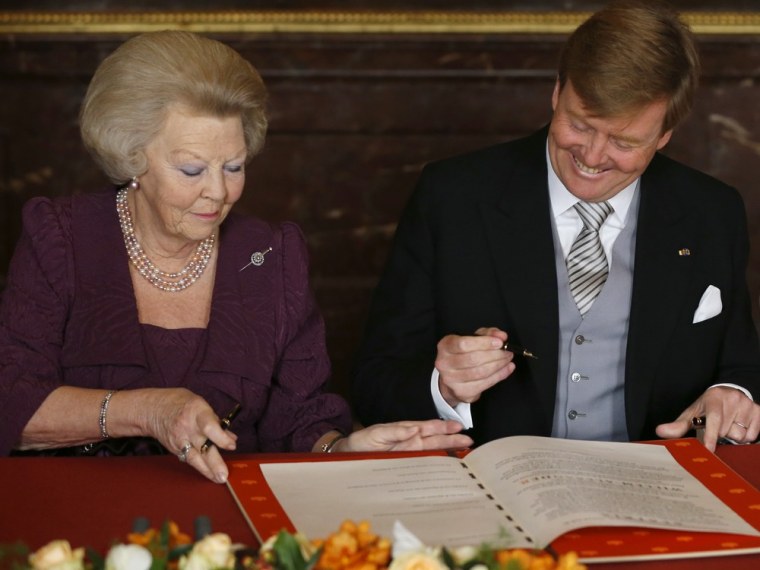 Dutch Princess Beatrix, left, gives to her son, King Willem-Alexander, the Act of Abdication, which she signed to end her reign as monarch on Tuesday.