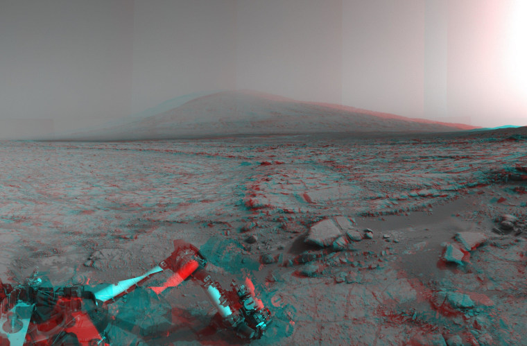 A stereo image from NASA's Mars Curiosity rover shows the terrain between the robot and Mount Sharp (a.k.a. Aeolis Mons) inside Gale Crater. Wear red-blue glasses to get the 3-D effect, and don't dwell too much on the hardware in the foreground. Trying to focus in on that part of the picture can make you go crosseyed.