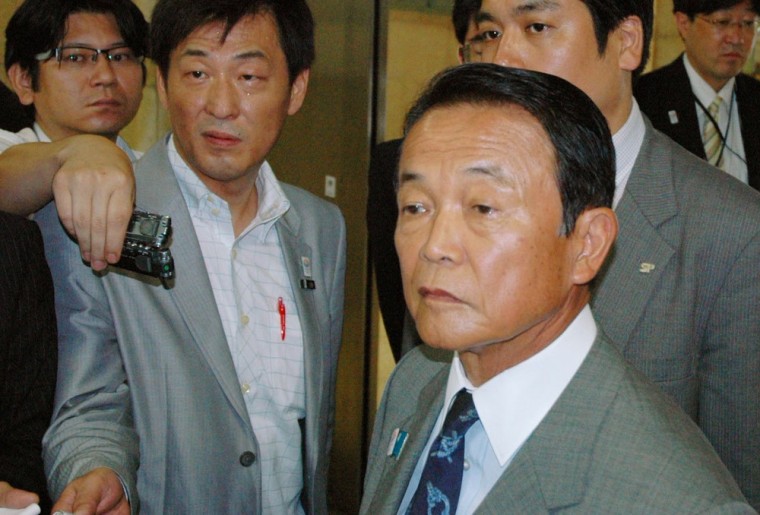 Taro Aso is surrounded by reporters in Tokyo, Thursday.