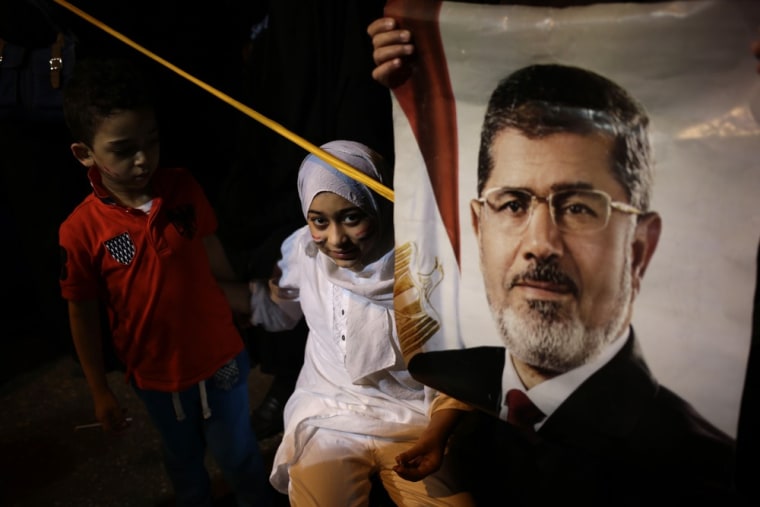 A child stands next to a poster of the Egypt's ousted President Mohammed Morsi outside Rabaah al-Adawiya mosque, Egypt, Wednesday.