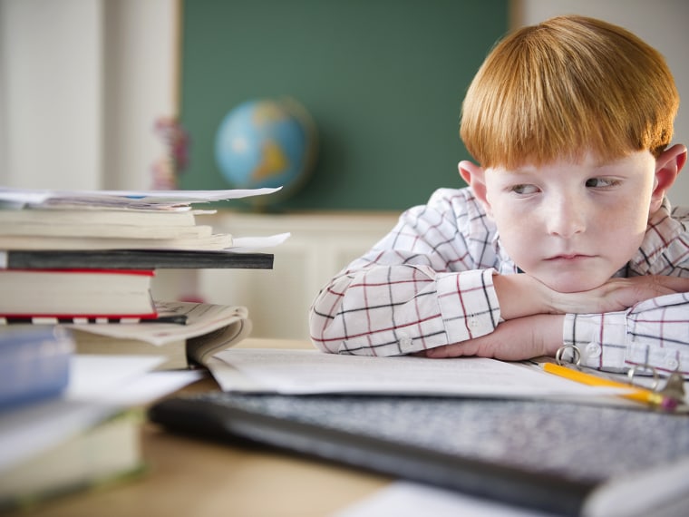 USA, New Jersey, Jersey City, Boy (8-9) sitting at crowded desk in classroom