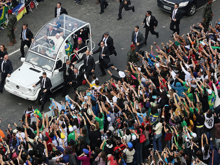 Pope Francis waves from the Popemobile as he arrives to celebrate Mass on Copacabana beach.