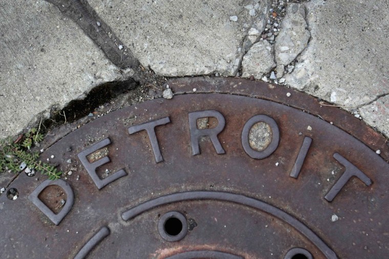 'Detroit' is seen on the top of an iron man-hole cover on a street in Detroit, Michigan July 27, 2013.