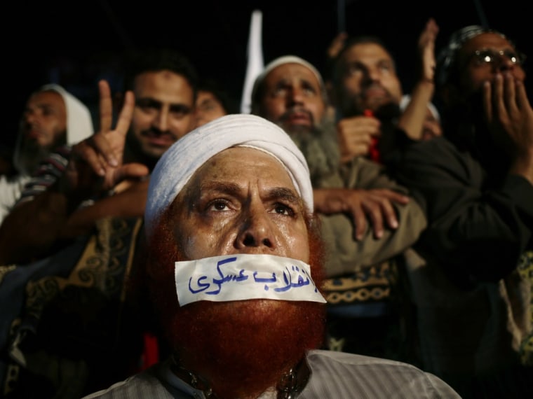 A supporter of Egypt's ousted President Mohammed Morsi covers his mouth with a sticker that reads