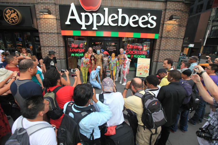 Nudists pose in front of an Applebee's restaurant near New York's Times Square as they participate in a public body painting event by artist Andy Golu...