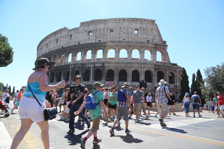 Pedestrians swarm around the Coliseum in Rome Saturday after cars were banned from part of the Via dei Fori Imperiali.