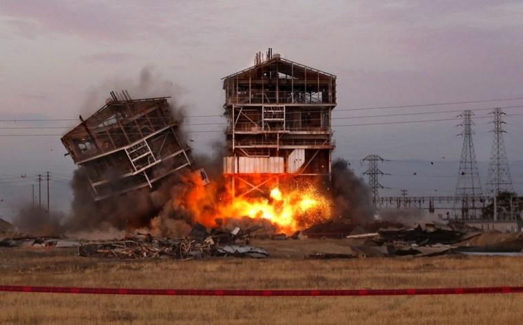 An explosion knocks down one of the remaining towers at the old Kern Power Plant, Saturday, Aug. 3, 2013 in Bakersfield, Calif.