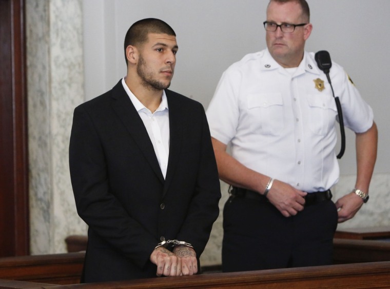 Former New England Patriots NFL football tight end Aaron Hernandez, left, appears at Attleboro District Court on Wednesday, July 24, 2013, in Attleboro, Mass.