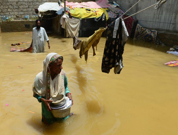 A Pakistani woman walks through floodwaters following heavy monsoon rains in Karachi on Monday.