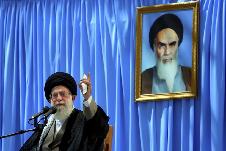 Supreme Leader Ayatollah Ali Khamenei delivers a speech in a ceremony marking the anniversary of the death of the late revolutionary founder Ayatollah Khomeini, shown in the picture in background, at his shrine just outside Tehran on Tuesday.