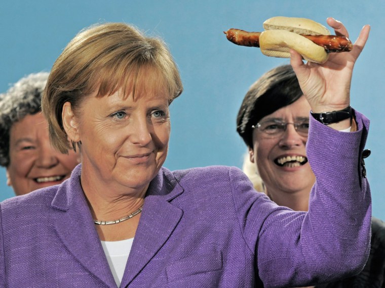 German Chancellor Angela Merkel holds up a Thuringian grilled sausage during an election campaign tour in Erfurt, Germany, in 2009.