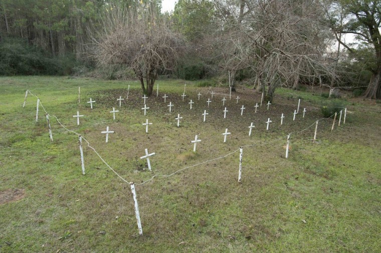 White metal crosses mark graves at the cemetery of the former Arthur G. Dozier School for Boys in Marianna, Florida,