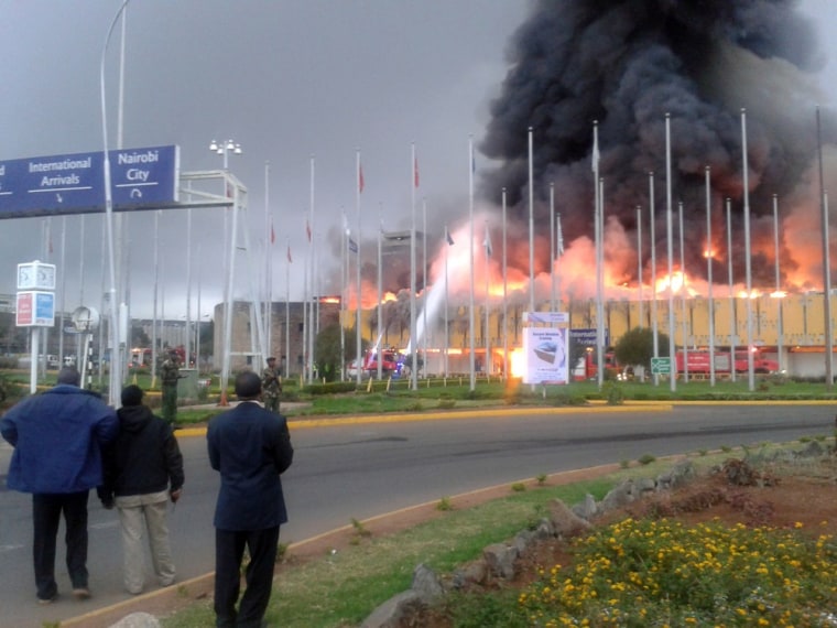 Onlookers watch as black smoke billows from the international arrival unit of Jomo Kenyatta International Airport in Nairobi, Kenya, on Wednesday.