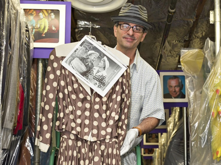 Owner James Comisar holds up Lucille Ball's dress prior to its being auctioned off.
