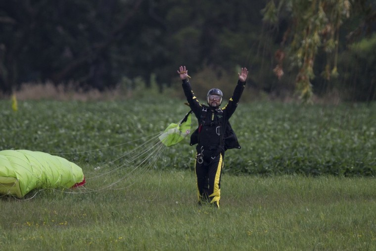 Escape artist Anthony Martin raises his hands in celebration after successfully escaping from handcuffs and a box he was locked in after being dropped from an airplane on Tuesday.