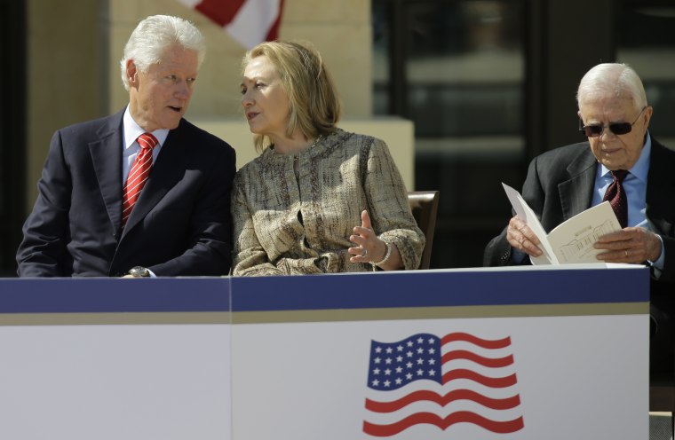 Former president William J. Clinton speaks with his wife former first lady Hillary Clinton during the dedication of the George W. Bush Presidential Center Thursday, April 25, 2013, in Dallas. At right is former president former president Jimmy Carter.