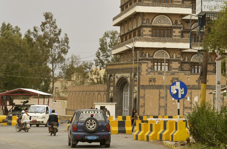 Vehicles and motorbikes drive past barriers blocking access to the U.S. Embassy in Sana'a, Yemen, on Aug. 3.
