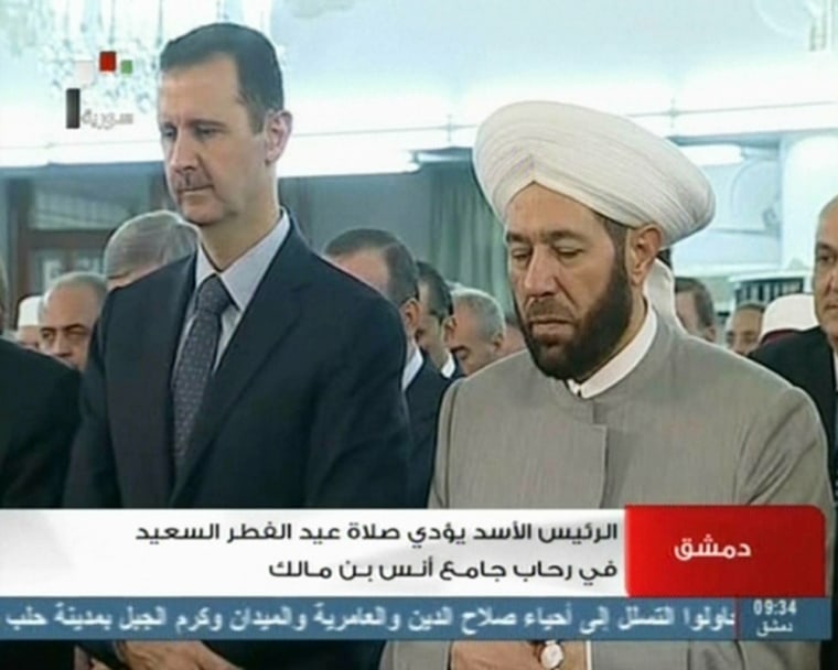 State-run Syrian television showed footage of President Bashar Assad (left) and Syrian Grand Mufti Ahmed Hassun attending the morning prayer in Damascus.