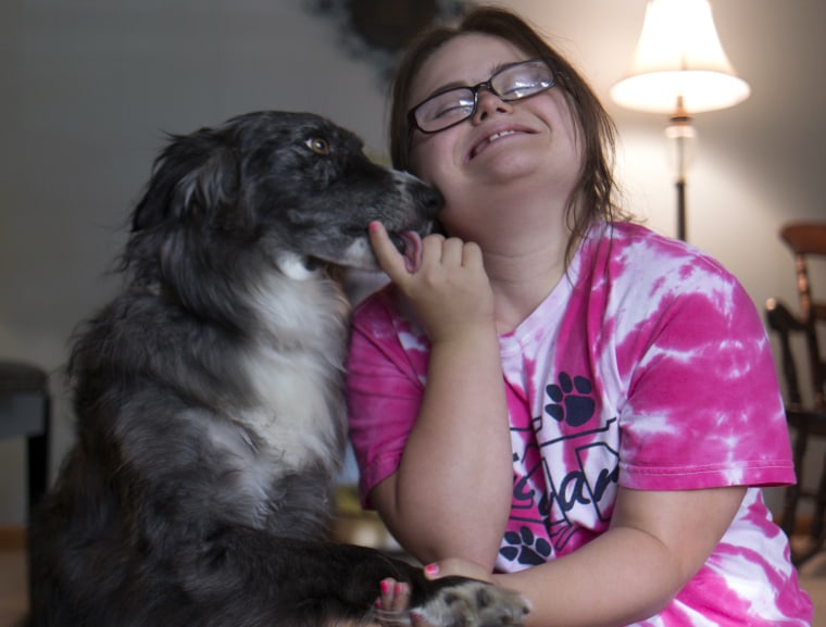 Rachel Mast, 14, plays with her dog, Dora at home in Olathe, KS, Aug. 6, 2013. Rachel has Downs Syndrome.