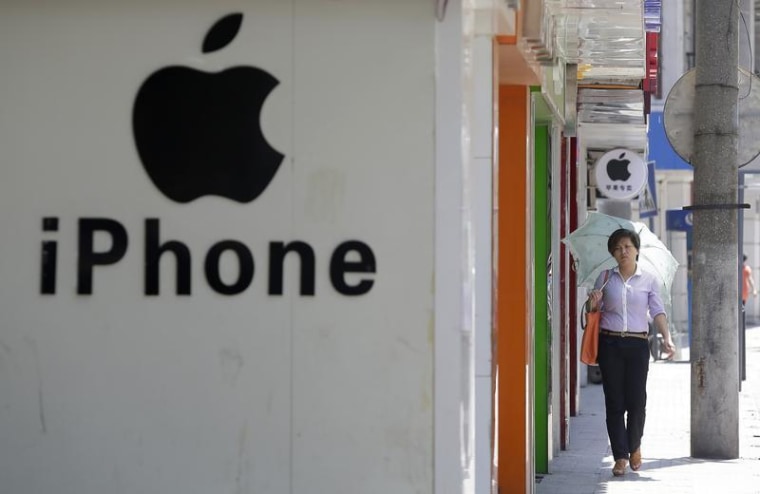 A woman walks past a logo of Apple Inc in Wuhan, Hubei province July 24, 2013. REUTERS/Darley Shen