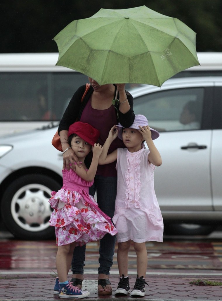 Two girls stay close to their mother during heavy rain in Manila, Philippines, on Sunday.