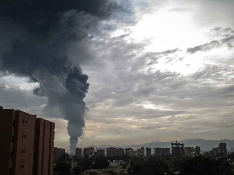 A general view of the Venezuelan city Puerto La Cruz shows the smoke caused by a fire in the government oil company PDVSA in Venezuela on August 11. PDVSA informed that the fire is now under control, residents surrounding the plant were evacuated. Officials say a storage tank was struck by lightning which started the fire.