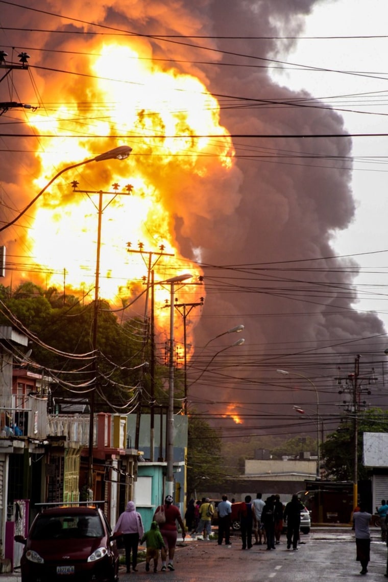 A massive fire blazes from an oil tank in the government oil company PDVSA in Puerto La Cruz, on the Caribbean coast of Venezuela on August 11. PDVSA informed that the fire is now under control but residents surrounding the plant were evacuated. Officials say a storage tank was struck by lightning which started the fire.