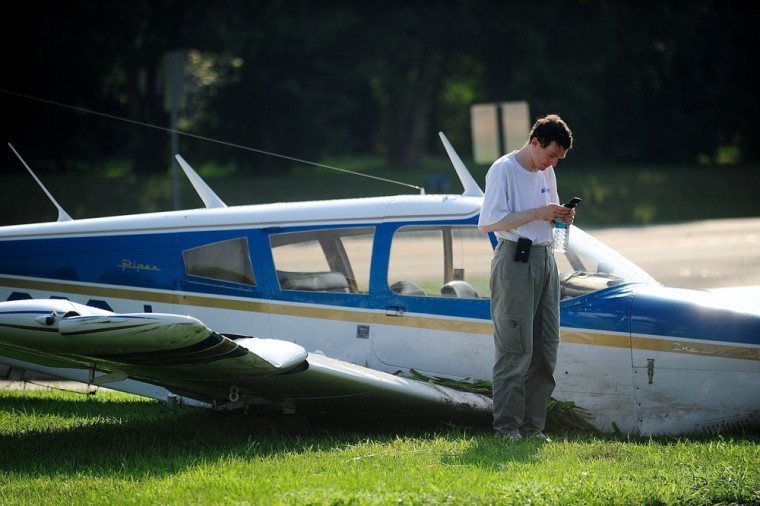 Jerome Matthew Orlando makes a phone call near the wreckage of the Piper airplane he crash landed on the grounds of WaWa on Tidewater Trail, after his small plane ran out of fuel on Monday Shannon Airport.