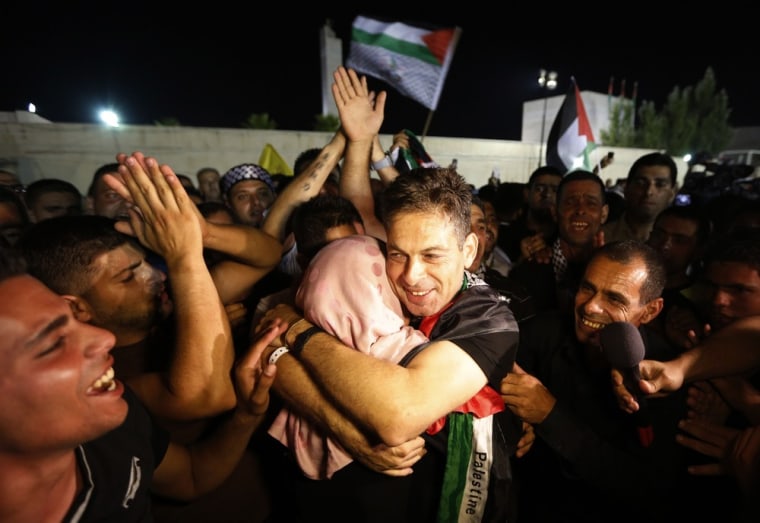 A freed Palestinian prisoner hugs a relative after his arrival in the West Bank city of Ramallah, Wednesday.