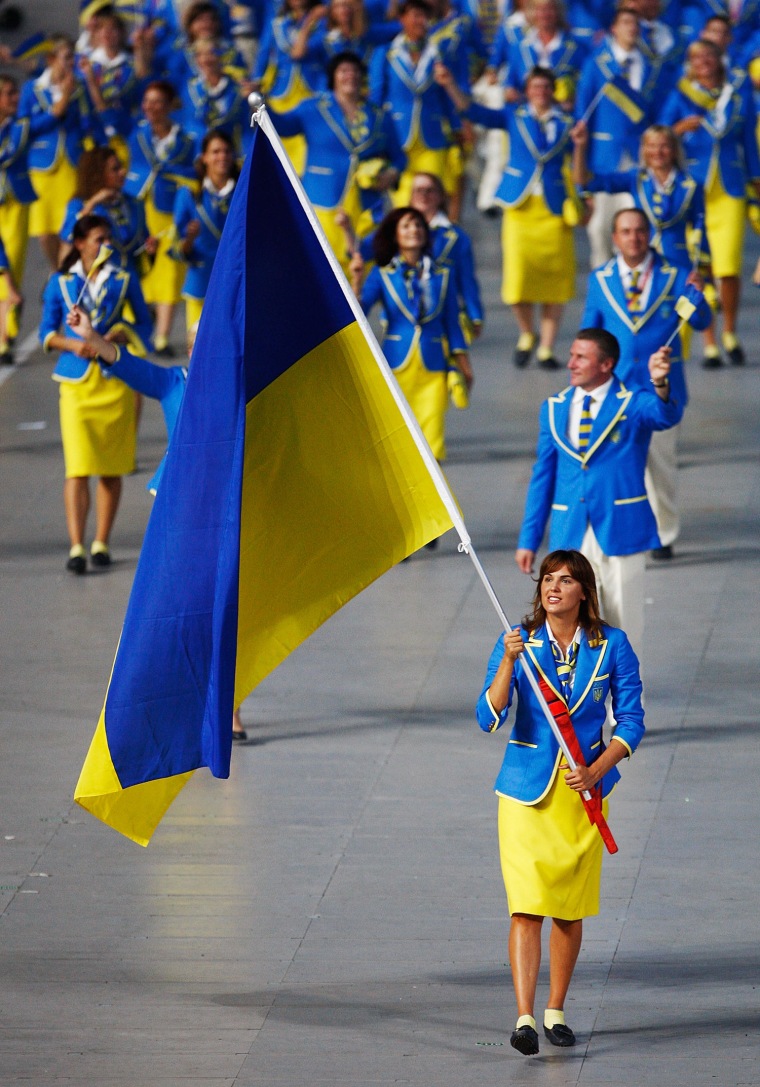 Yana Klochkova of the Ukraine Olympic team carries her country's flag at the 2008 Beijing Summer Olympics.
