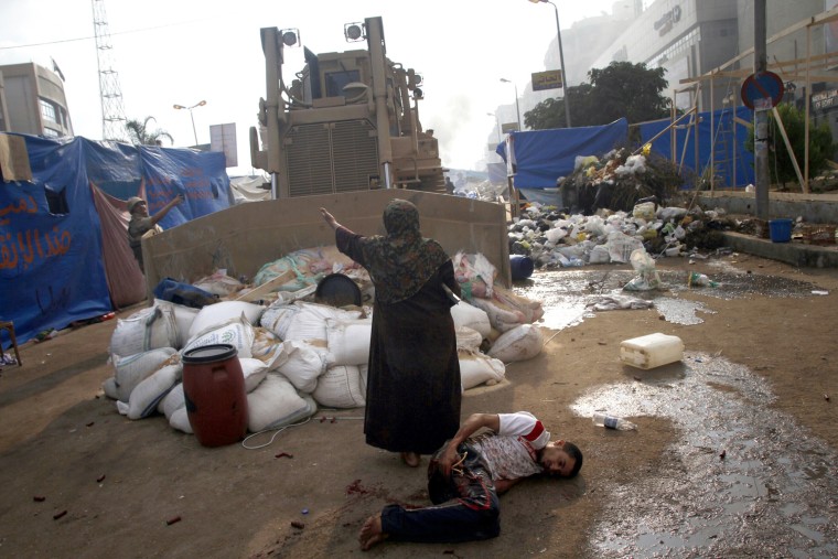 An Egyptian woman tries to stop a military bulldozer from hurting a wounded youth during clashes that broke out as Egyptian security forces moved in to disperse supporters of Egypt's deposed president Mohamed Morsi in a huge protest camp near Rabaa al-Adawiya mosque in eastern Cairo on August 14. The operation began shortly after dawn when security forces surrounded the sprawling Rabaa al-Adawiya camp in east Cairo and a similar one at Al-Nahda square, in the centre of the capital, launching a long-threatened crackdown that left dozens dead.