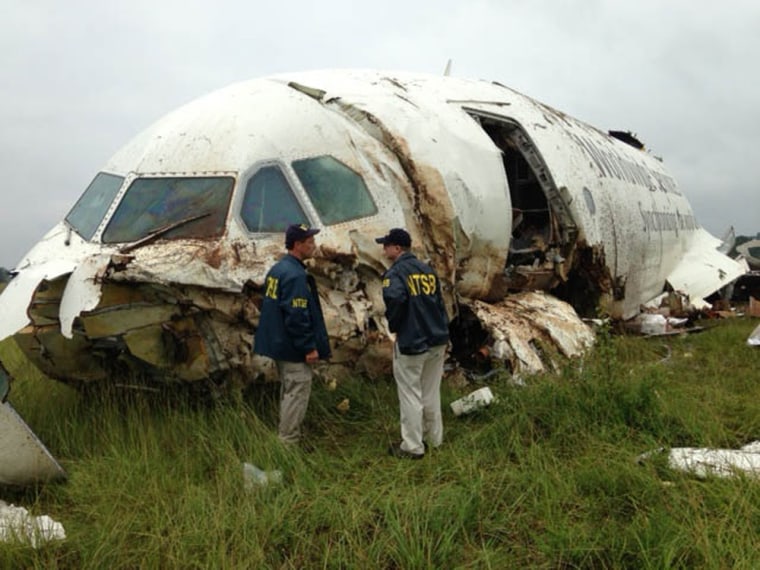 National Transportation Safety Board investigators near the remains of the plane.
