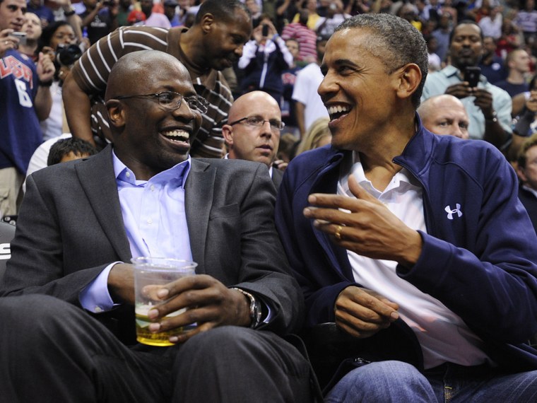 U.S. President Barack Obama shares a laugh with former White House aide Reggie Love as they watch the US Senior Men's National Team and Brazil play during a pre-Olympic exhibition basketball game at the Verizon Center on July 16, 2012 in Washington, DC.