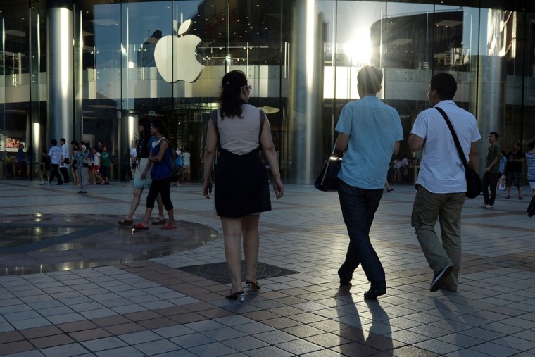 Shoppers walk outside an Apple store at the Wangfujing shopping street in Beijing on July 24, 2013. Apple said its revenue from China fell 14 percent...