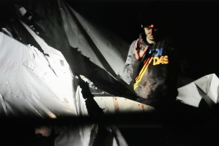 In this Friday, April 19, 2013 Massachusetts State Police photo, 19-year-old Boston Marathon bombing suspect Dzhokhar Tsarnaev raises his hand from a boat at the time of his capture by law enforcement authorities in Watertown, Mass.