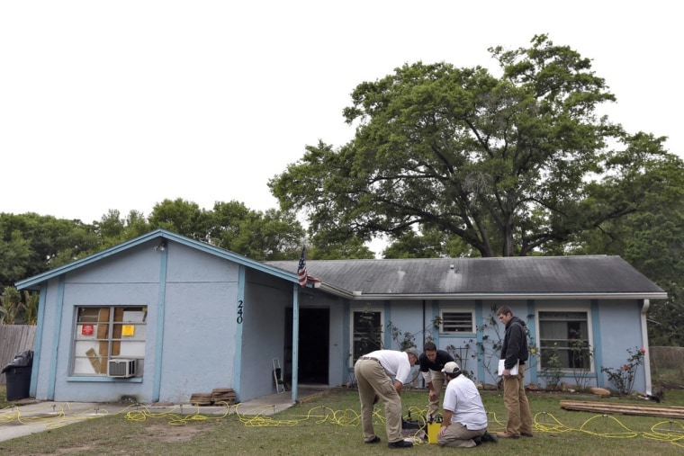 Engineers work in front of a home where sinkhole opened up underneath a bedroom and swallowed a man on March 1 in Seffner, Fla.