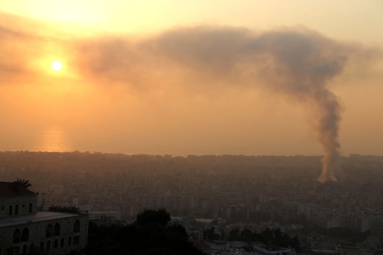 Smoke rises behind buildings from the site of an explosion in Beirut's southern suburbs, on Aug. 15.